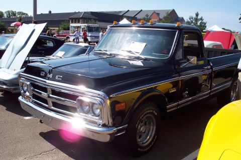 2001 Ford Crown Victoria - A vintage black GMC pickup truck is displayed at an outdoor car show.