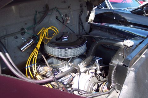 2001 Ford Crown Victoria - A look inside the engine compartment of a vintage automobile, with another vehicle visible behind it.