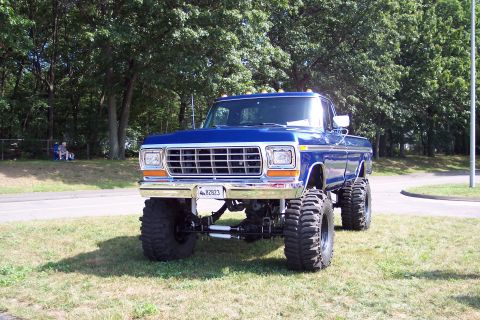2001 Ford Crown Victoria - This lifted 1979 Ford pickup truck is parked on a grassy area with trees in the background.