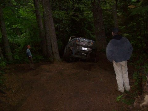 1985 Toyota Pickup/SR5 - Off-road vehicle stuck in the dirt on a wooded trail.