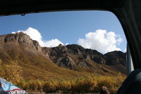 1990 Chevrolet Suburban - Autumn colors paint the mountainside, seen through a car window.