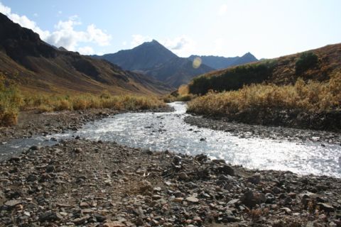 1990 Chevrolet Suburban - A scenic view of a mountain valley a river flowing through a rocky terrain.