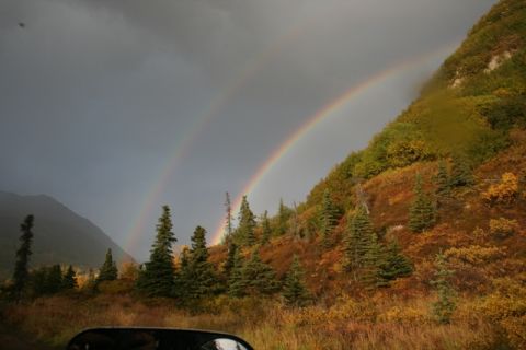 1990 Chevrolet Suburban - A double rainbow arcs over a mountainside covered in autumn colors, viewed from a car.