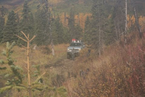 1990 Chevrolet Suburban - A 1990 Chevrolet Suburban navigates a dirt trail through a wooded area during autumn.