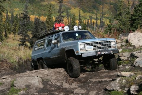 1990 Chevrolet Suburban - This 1990 Chevrolet Suburban navigates a challenging rocky trail with its tires covered in mud.