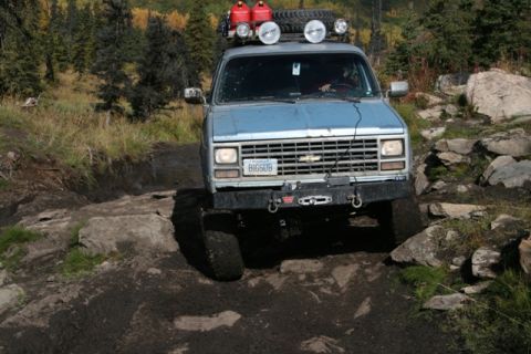 1990 Chevrolet Suburban - This 1990 Chevrolet Suburban navigates a challenging off-road course, demonstrating its capability on rough terrain.