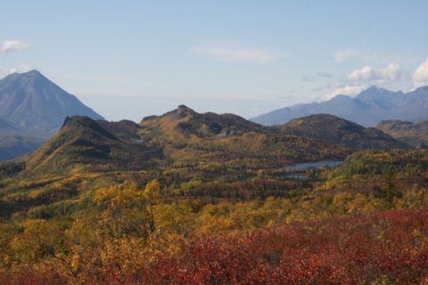 1990 Chevrolet Suburban - A scenic view of mountains covered in colorful autumn leaves, with a small lake visible in the distance.