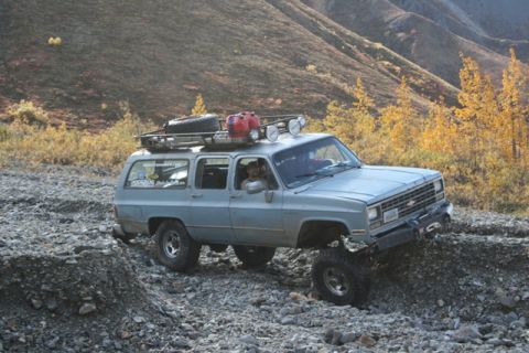 1990 Chevrolet Suburban - A modified Chevrolet Suburban navigates a , mountainous terrain during autumn.