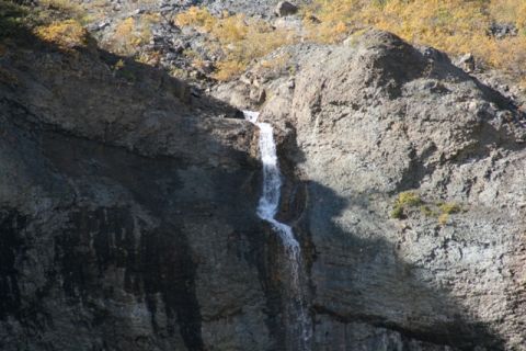 1990 Chevrolet Suburban - A small waterfall flows down a , rocky mountainside during the autumn season.