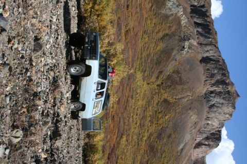1990 Chevrolet Suburban - 1981 Chevrolet K5 Blazer on a rocky trail, with a mountain landscape and autumn colors.