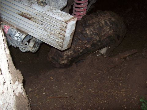 1985 Toyota Pickup/SR5 - The rear suspension and a large, muddy tire of a 1985 Toyota Pickup/SR5 are shown from the side.