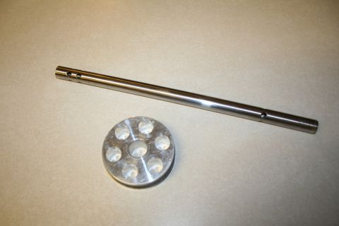 1984 Ford Bronco - Two metal parts, likely for a shock absorber assembly, are laid out on a neutral surface.