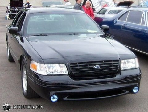 1900 Bentley Turbo - A black Ford Crown Victoria is parked outdoors with other vehicles visible in the background.