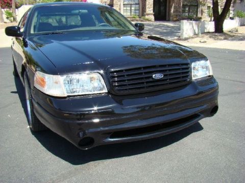 1900 Bentley Turbo - A black Ford Crown Victoria is shown from the front, parked on asphalt with a building in the background.