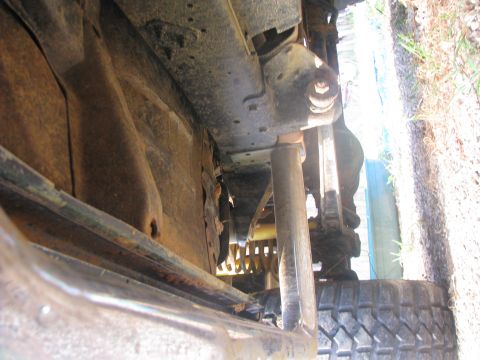 1979 Ford Bronco - This photo shows the rusty undercarriage and suspension components of a vehicle, including a tire.