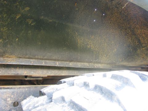 1979 Ford Bronco - A close-up view of a vehicle's undercarriage and tire, revealing signs of wear and rust.