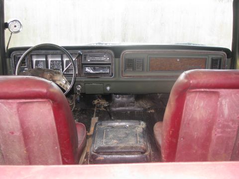 1979 Ford Bronco - The interior of a 1978 Ford Bronco shows its red seats and green dashboard with an added gauge.