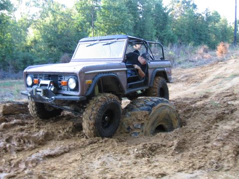 1967 Ford Mustang - This brown Ford Bronco is stuck deep in the mud, with one tire submerged.