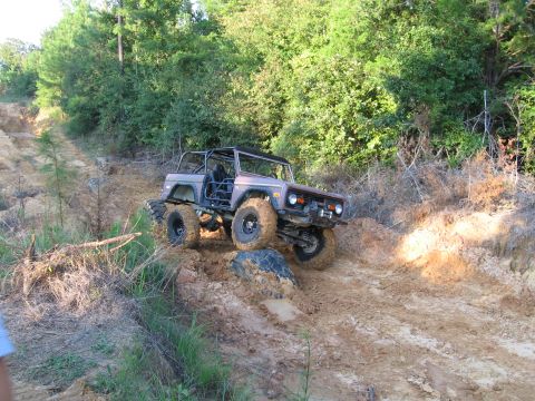 1967 Ford Mustang - This modified Ford Bronco is tackling a challenging muddy hill during an off-road excursion.