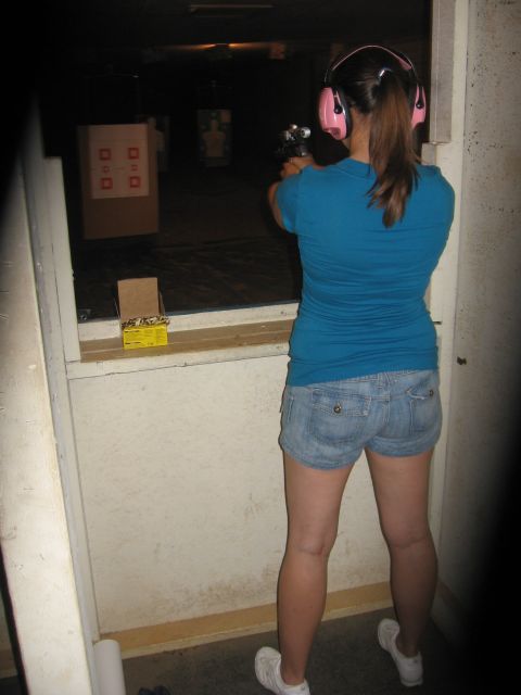 2001 Ford F-150 - A woman practices her aim at an indoor shooting range, wearing protective earmuffs and holding a handgun.