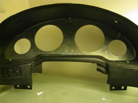 1994 Ford Probe - This is a close-up view of a car's instrument cluster housing, showing the openings for the gauges and a control switch.