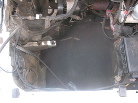 1996 Ford C-350 (Centurion Conversions) - Close-up view of various engine bay components including hoses, wiring, and a fuse box.