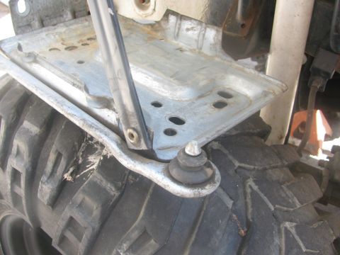 1996 Ford C-350 (Centurion Conversions) - Detail of a vehicle's suspension component and off-road tire tread.