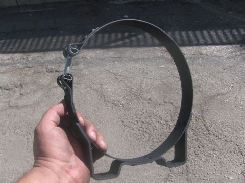 1996 Ford C-350 (Centurion Conversions) - A black metal air intake clamp is held in a hand against a cracked asphalt background.