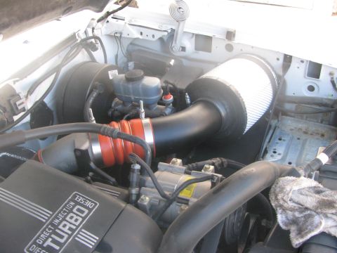 1996 Ford C-350 (Centurion Conversions) - Aftermarket cold air intake system installed in the engine bay of a diesel truck.
