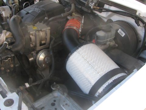 1996 Ford C-350 (Centurion Conversions) - Engine bay of a 1996 Ford C-350 (Centurion Conversions) with a prominent aftermarket air intake system.