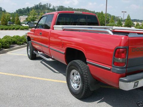1989 Ford Bronco - This red pickup truck is seen from the rear quarter angle, a toolbox mounted in the bed.