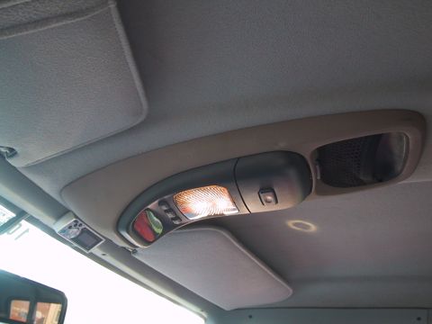1994 Ford Bronco - Interior view of a vehicle's overhead console, showing the light, buttons, and a sun visor.