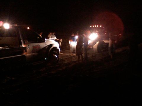 1998 Dodge 1500 - Several vehicles and people are visible at night, illuminated by headlights.