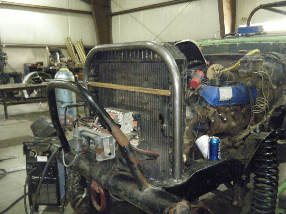 Custom roll cage over radiator and exposed engine of a modified vehicle