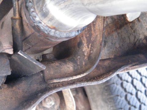 1982 Ford Bronco - Welding work on a vehicle's exhaust system is visible, with a tire in the background.