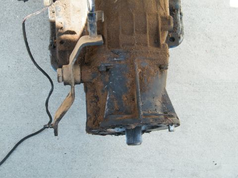 1982 Ford Bronco - A dirty transmission part, possibly from a 1982 Ford Bronco, is shown with its splined output shaft visible.