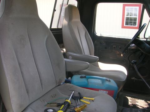 1975 Ford F-250 - Interior of a truck cab with tools and a fuel can on the passenger seat.