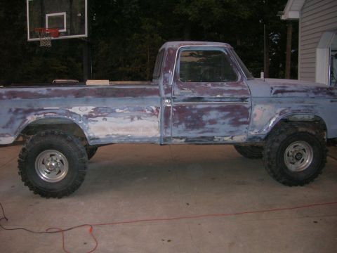 1975 Ford F-250 - This 1975 Ford F-250 pickup truck is undergoing bodywork and is lifted with large tires.