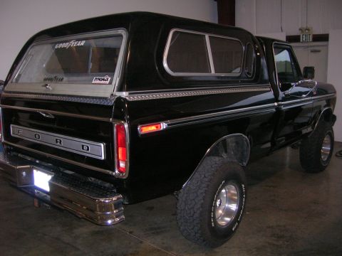 1975 Ford F-250 - This black 1975 Ford F-250 pickup truck is equipped with a camper shell and chrome accents.