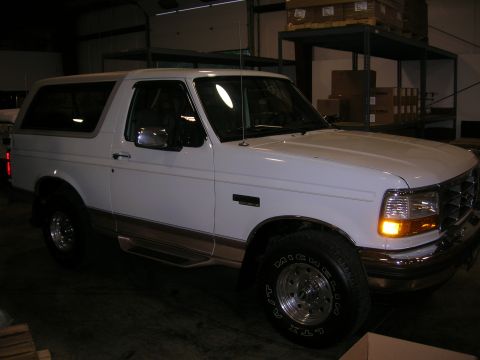 1975 Ford F-250 - This white Ford Bronco is shown from the front three-quarter angle inside a garage or warehouse.