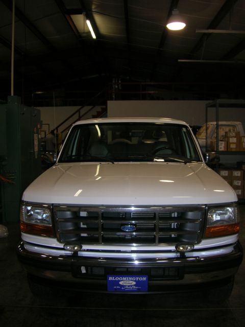 1975 Ford F-250 - This white Ford F-Series truck is parked indoors, showing its front grille and headlights.