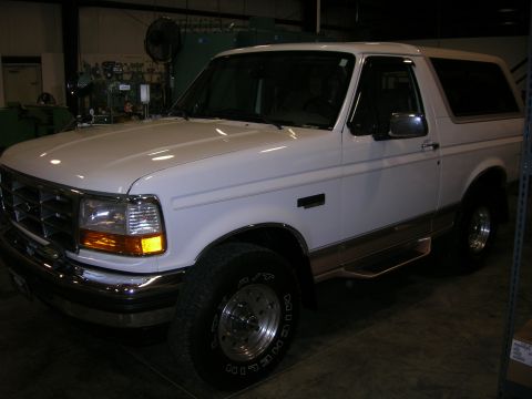 1975 Ford F-250 - This white Ford Bronco is shown from a three-quarter front view, parked indoors.