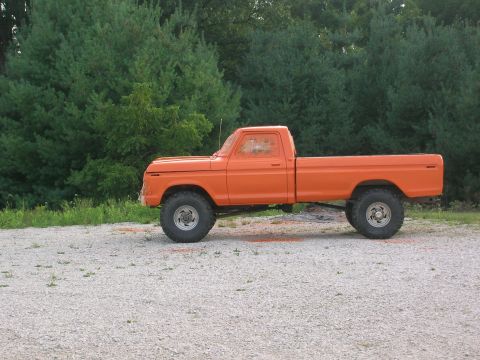 1975 Ford F-250 - This orange pickup truck, likely from the early to mid-1970s, is shown from the side on a gravel lot.