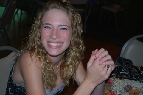 1996 Ford Bronco - A woman with blonde curly hair smiles broadly while sitting at a table.
