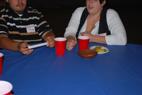 1996 Ford Bronco - People sit at a table with red cups, a bowl, and a banana, with name tags visible.