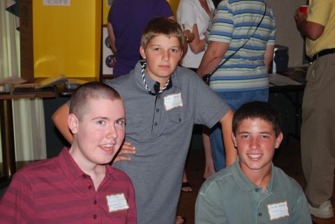 1996 Ford Bronco - Three young males wearing name tags pose for a photo at an indoor event.