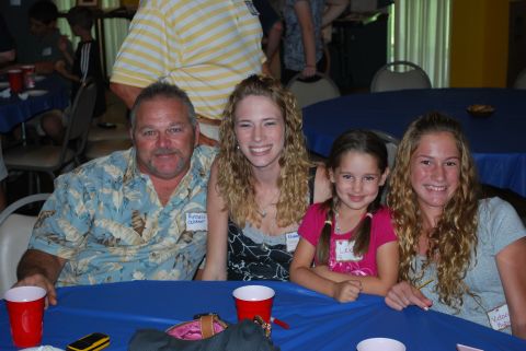 1996 Ford Bronco - A family poses for a photo at a reunion event, seated around a blue table with red cups.