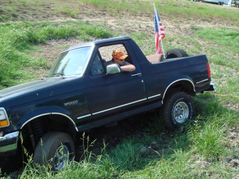 1992 Ford Bronco - A 1992 Ford Bronco navigates an off-road course, flying an American flag from its bed.