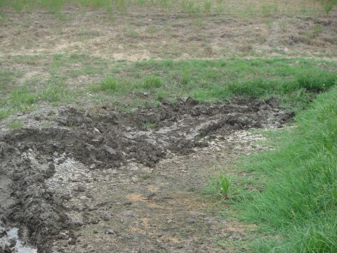 1992 Ford Bronco - Muddy ground with visible tire tracks, suggesting off-road activity. The Supermotors logo is visible in the lower right corner.