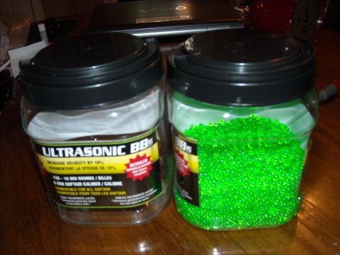1979 Ford F-150 - Two jars of BBs sit on a wooden surface, one filled with green pellets and the other empty.